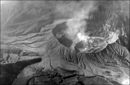 In June 1956, steam rises from a new circular sub-crater formed in the summit crater of Poás during an eruption from 1952-57. It began with phreatic explosions increasing in intensity from 1952 to early 1953. By May 22 1953, the crater lake was vaporized. Then slabs of lava appeared in the crater in 1957. © Jorge Barquero (Universidad Nacional Costa Rica), 1956.