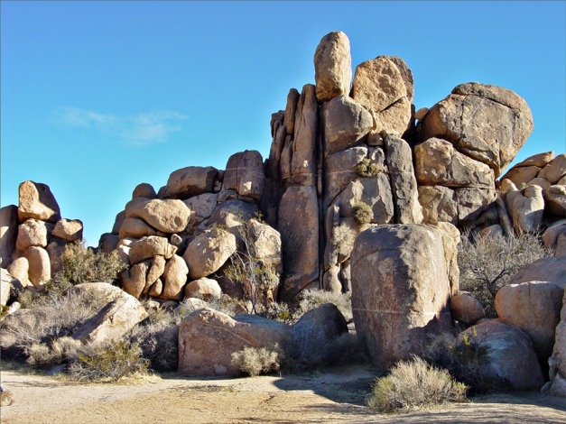 Spherically weathered boulders of granite in Joshua Tree National Park. The original fractures between boulders are still visible in many parts of this desert outcrop. Finer sediments derived from the breakdown of the granite has been removed by erosion. (Img and txt from: GeologyCafe.com)