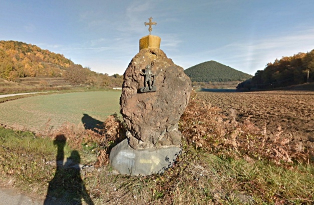Large lava bomb placed by the roadside, with Volcá del Croscat in the background. 2017. (© screenshot from Google StreetView)