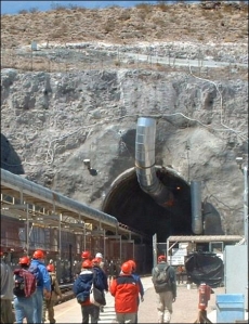 A tour group entering the North Portal of the Yucca Mountain nuclear waste repository. This is also the place where excavation by a tunnel boring machine (TBM) began that dug the main tunnel into the ignimbrite. (© Daniel Mayer, Wikipedia)